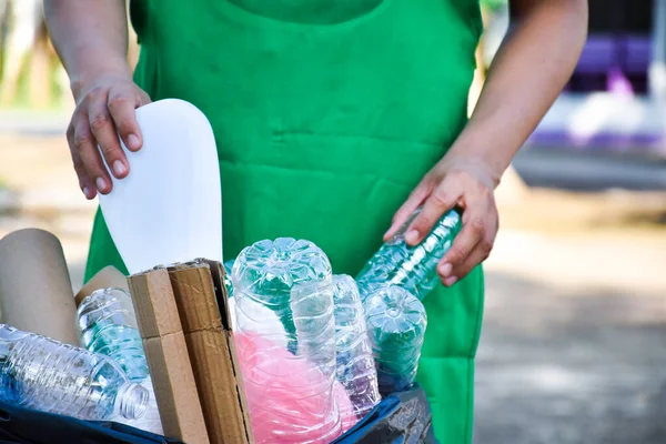 Plastik konteynırları siyah plastik torbaya yerleştirir.
