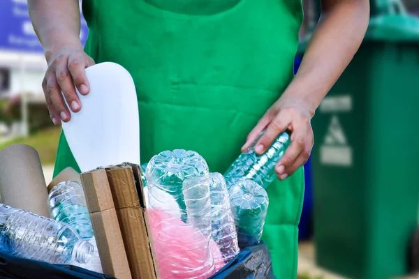 Plastik konteynırları siyah plastik torbaya yerleştirir.