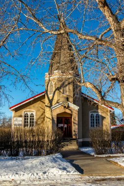 Ağaçlara kurulmuş tarihi eski bir kilise. Three Hills, Alberta, Kanada