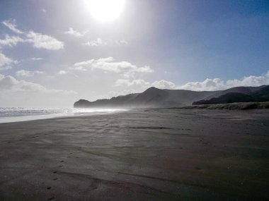 Siyah kumlu plajlar bölgeyi aydınlatıyor. Auck; ve, Yeni Zelanda