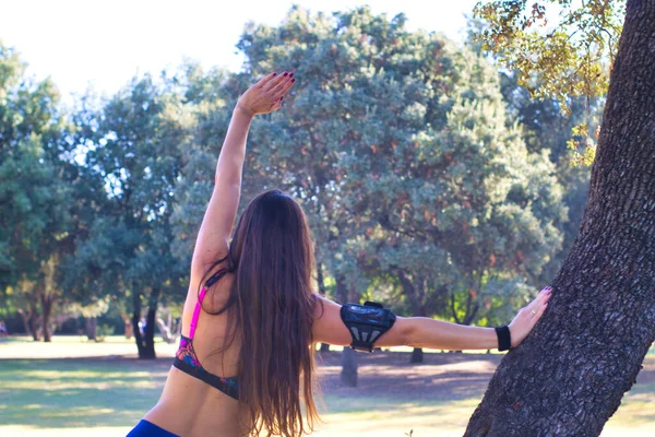 Mujer Joven Calentando Sesión Funcionamiento Parque Apoyado Contra Árbol — Foto de Stock