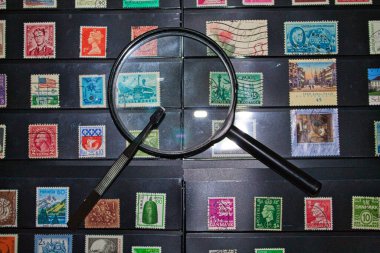 philately magnifying glass and tweezers ready to see the world stamp collection clipart