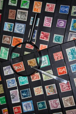 philately magnifying glass and tweezers ready to see world stamps collection clipart