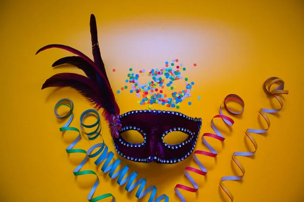 Purple Carnival Mask Confetti Curly Paper Yellow Background — Stock Photo, Image