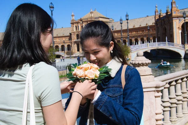 Asiatka Dává Kytici Růží Své Mladší Sestře Pozadí Velký Čtverec — Stock fotografie