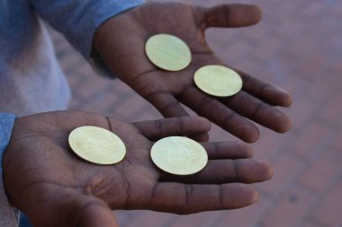 Afro-Amerikan adamın elinde dört Bitcoin siber para var. Gelecek onun ellerinde..