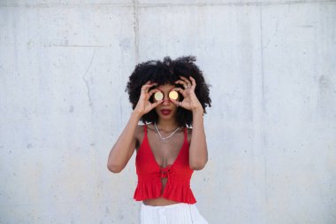 beautiful afro-american woman covers her eyes with a pair of cyber coins. Concept bicoin, internet, online investment