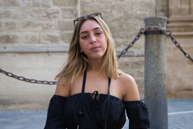 Genç ve güzel sarışın kadın tatillerde kameraya bakarken yüzüyle farklı jestler ve ifadeler yapıyor. Tatil ve seyahat kavramı