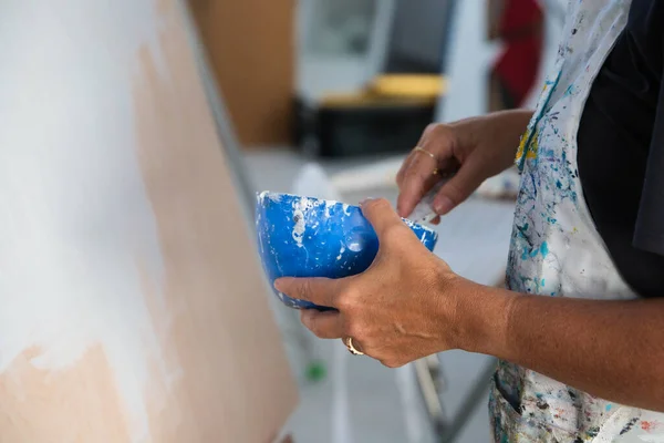 Зрелая Женщина Очках Рисует Белый Фон Женщина Держит Руках Голубую — стоковое фото