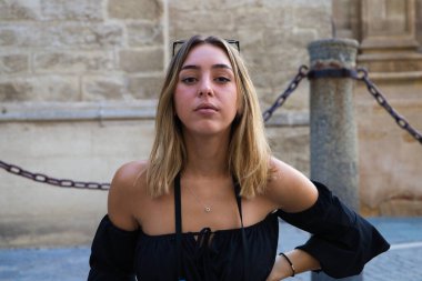 Genç ve güzel sarışın kadın tatillerde kameraya bakarken yüzüyle farklı jestler ve ifadeler yapıyor. Tatil ve seyahat kavramı