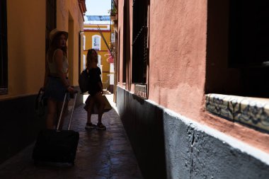 Bir Avrupa şehrinde dar bir sokakta yürüyen iki güzel genç kadın. Kadınlar tekerlekli bavullarını taşıyorlar ve tatillerini geçirecekleri otele gidiyorlar..