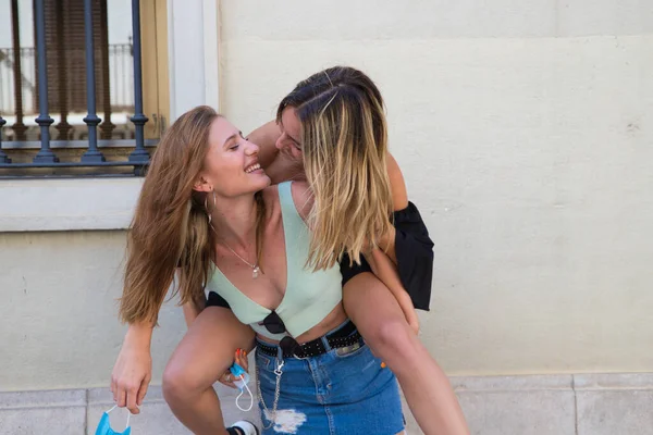 stock image two beautiful young women on holiday. The women are lesbians and one is carrying the other. They are a couple. Concept of equality and diversity.