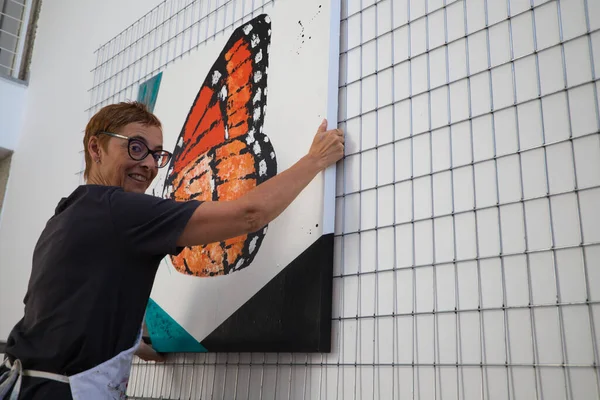 Femme Peintre Mature Accrochant Une Ses Peintures Dans Son Atelier — Photo