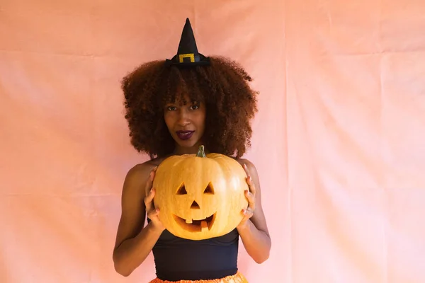 Молодая Африканская Американка Одетая Ведьма Хэллоуин Держащая Тыкву Руках Носит — стоковое фото