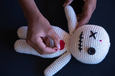 Bebek üzerinde vudu yapan cadı bir kadının detayları. Bebeğe nasıl iğne batırdığını görebilirsiniz. Büyücülük.