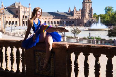 Klasik balerin ve parkta korkuluklara yaslanan lezbiyen. Ayakkabılarına sıkıştırılmış eşcinsel gurur bayrağını takıyor. Homoseksüellik ve bale kavramı