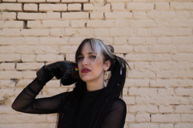 Serseri eğilimli genç ve güzel bir kız. Boks eldiveni giyiyor ve yüzüne yumruk atıyor. Kız kameraya bakıp eğlenirken farklı pozlar veriyor..