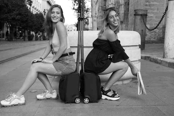 Dwie Młode Piękne Kobiety Zwiedzające Miasto Dziewczyny Siedzą Walizkach Pozują — Zdjęcie stockowe