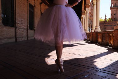 Klasik bir balerin bacakları. Elleri kalçasında parmak uçlarında durduğu bir balerin. Klasik bale
