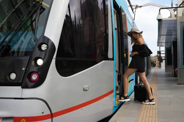 Genç ve güzel bir kadın tramvaya biniyor. Kadın şapka, kamera ve şehir haritası takıyor. Tatil, seyahat, turizm ve ekonomi kavramını.