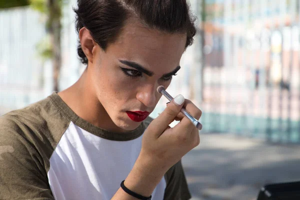 young latina transsexual woman is in a park where she is going to start doing her make-up for her big change from boy to girl. Concept of diversity, transgender, and freedom of homosexual expression.