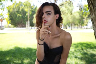 Genç Latin ve transseksüel kadın güzel siyah iç çamaşırı giymişler. Kadın kameraya poz veriyor, parmaklarıyla homofobikleri susturuyor. Farklılık, transseksüel ve özgürlük kavramları