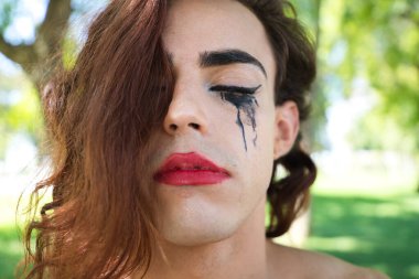 Genç Latin ve transseksüel kadın güzel siyah iç çamaşırı giymişler. Kadın, ayrımcılık yüzünden ağlamaktan maskarası bulaşmış bir şekilde kameraya poz veriyor. Farklılık kavramı, cinsiyet değiştirme, homofobi