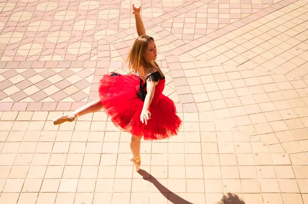 在街上跳舞的古典芭蕾舞演员 这位舞蹈演员穿着一件红色的晚礼服 正在表演一部西班牙的古典作品 你可以看到跳舞者在地板上的影子 古典芭蕾舞概念 — 图库照片