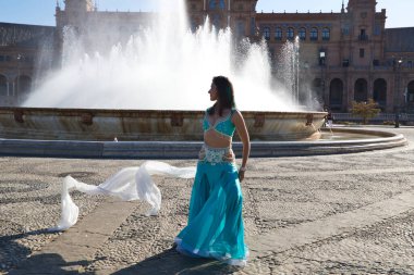 Meydanda dans eden genç ve güzel bir dansçı. O, elinde beyaz bir peçeyle açık mavi giyinmiş. Afrika ve Asya 'dan gelen dünya folklor kavramı.