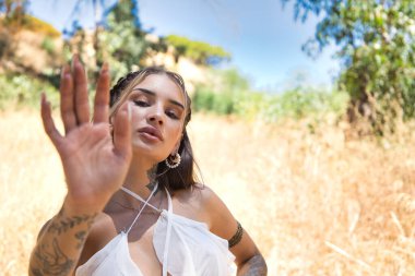 Genç bir kadın, önünde elini kaldırmış, eşitlik hakkı için mücadele ediyor ve kadınlara yönelik şiddet ve güvensizliğe, kadın mücadelesine ve kararlılığına son veriyor.