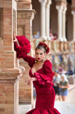 İspanya, Seville 'de bir meydanda, tuğla bir sütuna yaslanmış flamenko dansı yapan güzel bir kadın. O, kırmızı bir fırfırlı elbise giyiyor. Flamenko, insanlığın kültürel mirası.