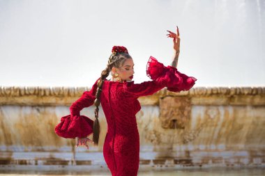 İspanya, Seville 'de bir meydanda flamenko dansı yapan güzel bir kadın. Fırfırlı kırmızı bir elbise giyiyor ve büyük bir sanatla flamenko dansı yapıyor. Flamenko, insanlığın kültürel mirası.