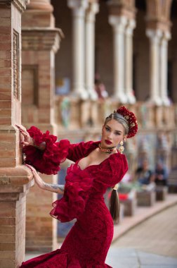 İspanya, Seville 'de bir meydanda, tuğla bir sütuna yaslanmış flamenko dansı yapan güzel bir kadın. O, kırmızı bir fırfırlı elbise giyiyor. Flamenko, insanlığın kültürel mirası.