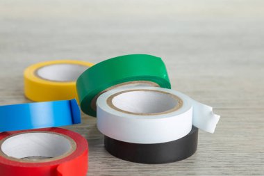 Altı rulo renkli bant kırmızı, mavi, sarı, yeşil, beyaz, siyah açık ahşap yüzey.