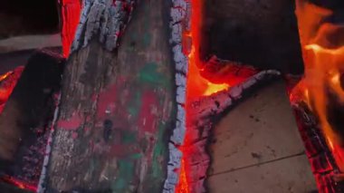 Sıcak turuncu ateş, kış boyunca açık havada kereste yakıyor. Akıllı telefon görüntüsü.