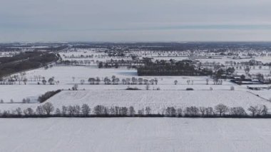 Uçsuz bucaksız karla kaplı bir Hollanda kırsalının insansız hava araçlarıyla çekilen çekimlerinde sessiz köyler ve uzak bir otoyol yer alıyor..
