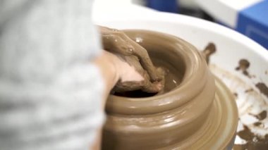 Çanak çömlek çarkında çalışan isimsiz kadına yakın durun..