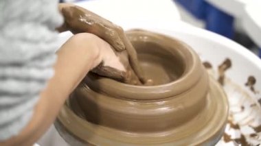 Çanak çömlek çarkında çalışan isimsiz kadına yakın durun..