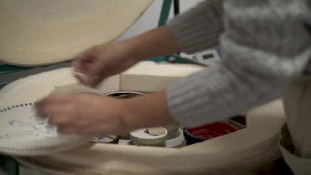 窯から陶器を取り出す女性陶芸家のクローズアップ — ストック動画
