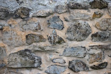 Taş bir duvarın dokusu. Eski kale taşından duvar dokusu. Arka plan ya da doku olarak taş duvar. Bir taş duvarın parçası, arkaplan veya doku için.