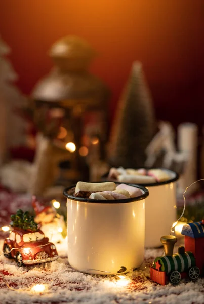 Noel süslemeleriyle çevrili sıcak çikolatalar. Marşmelovlu sıcak çikolata. Noel konsepti.