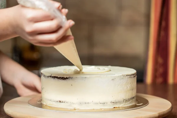 여자가 케이크를 부엌에서 꾸미고 있습니다 맛있어 — 스톡 사진