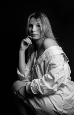 Derisinde çürükler olan üzgün, genç bir kızın stüdyo portresi. Beyaz tişörtlü kız..