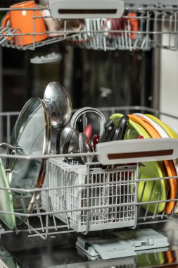 Kirli bulaşıkları olan açık bir bulaşık makinesi.