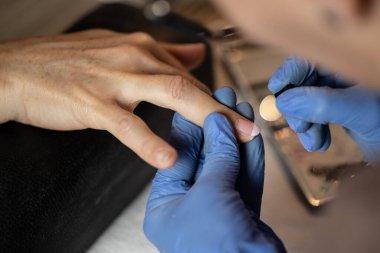 Manikürcüye manikür yaptıran bir kadının yakın plan fotoğrafı. Manikür yaptıran kadın..