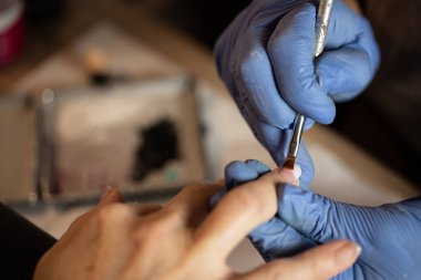 Manikürcüye manikür yaptıran bir kadının yakın çekimi..