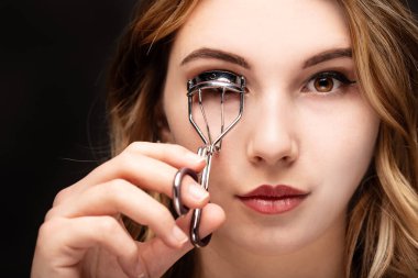 Makyaj yapan bir kızın stüdyo fotoğrafı.