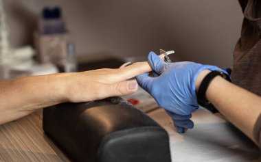 Manikürcüye manikür yaptıran bir kadının yakın çekimi..