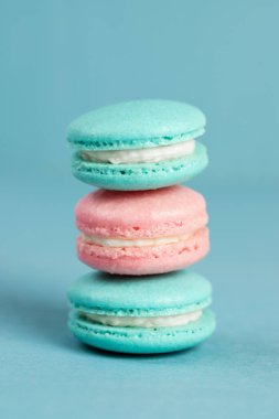 Mavi arka planda renkli, tatlı badem kurabiyeleri. Fransız tatlısı.