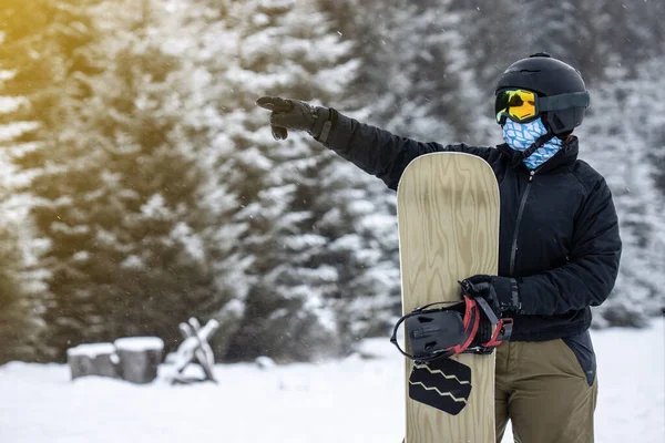 Молодая девушка сноубордистка показывает что-то — стоковое фото